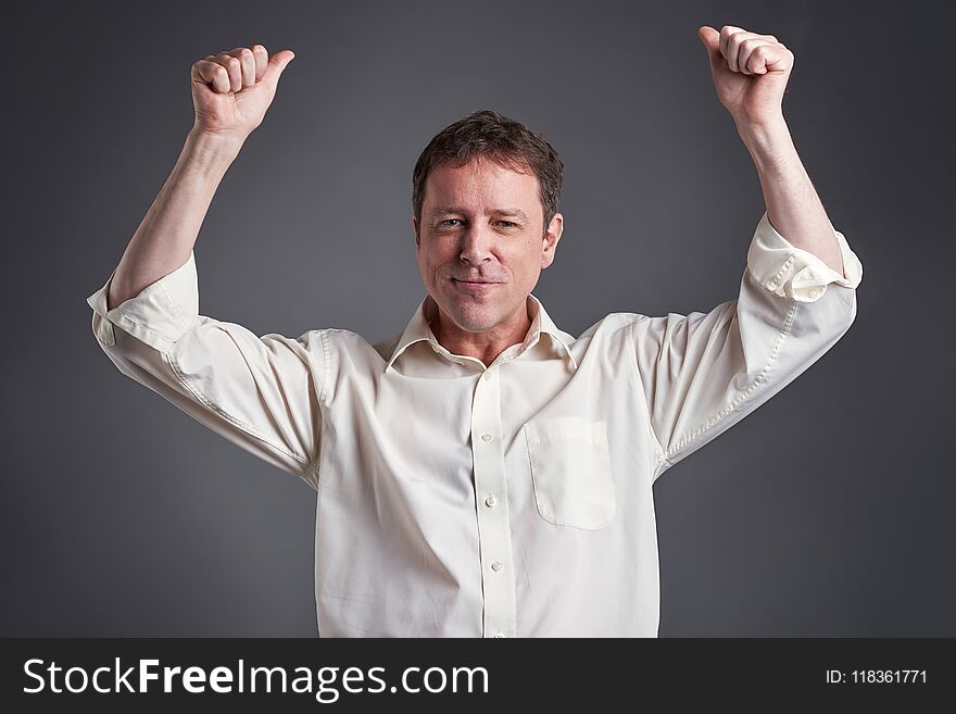 Portrait of a happy middle age man showing thumbs up and celebratingr. Portrait of a happy middle age man showing thumbs up and celebratingr