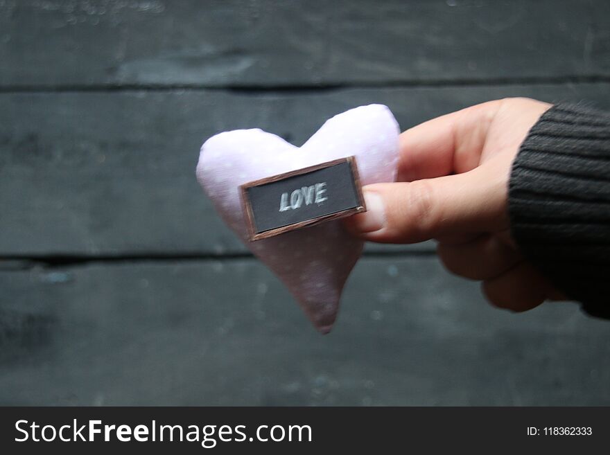 Valentines Day or love heart idea, hand holding a heart, vintage style. Blurred photos for the background. Valentines Day or love heart idea, hand holding a heart, vintage style. Blurred photos for the background.