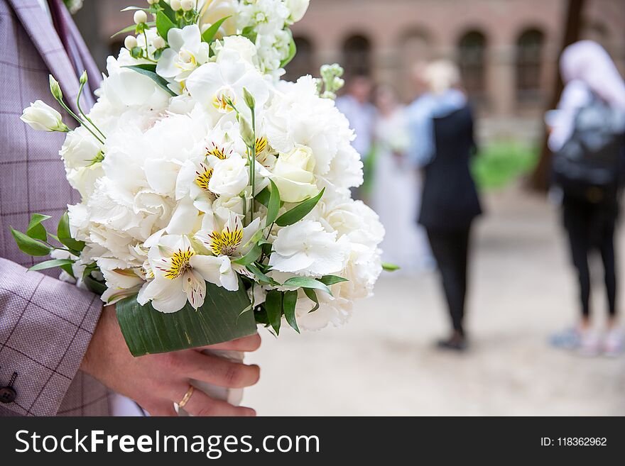 Bride and groom holding wedding white bouquet