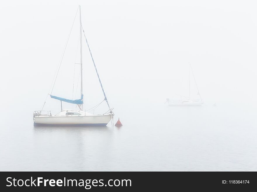 Sail boats in a foggy morning