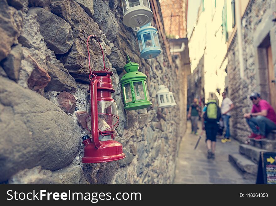 Colorful petroleum lamps hanging from a wall in narrow street.