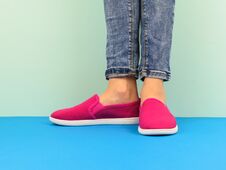 Hipster Girl`s Legs In Jeans On The Blue Floor By The Blue Wall. Modern Style. Stock Photography