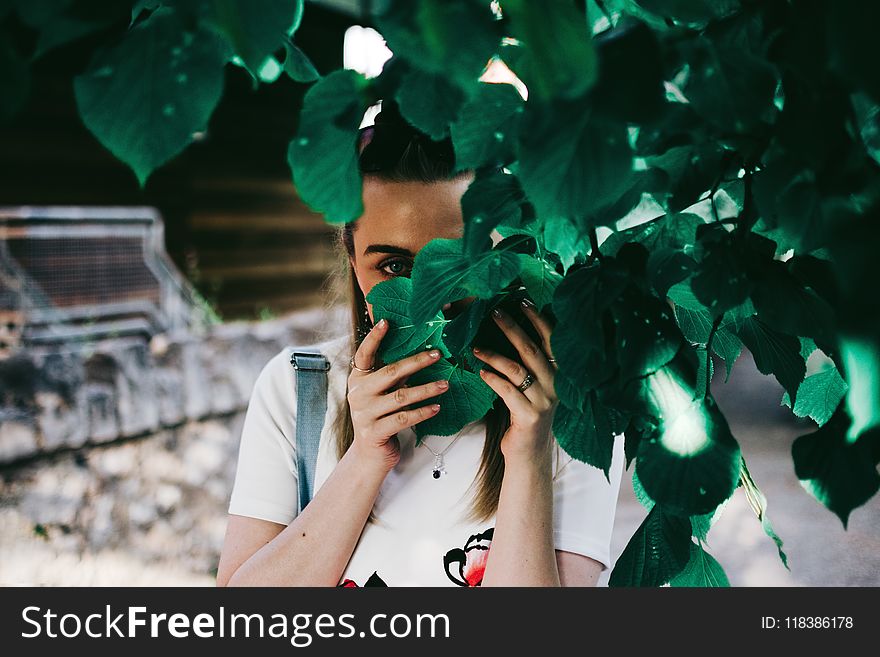 Woman Holding Leaves Covering Her Face