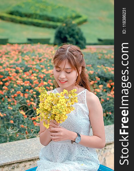 Woman Wearing White Top Holding Yellow Petaled Flowers