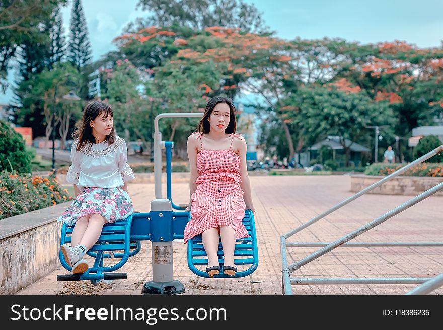 Two Woman Sitting at Park Ride