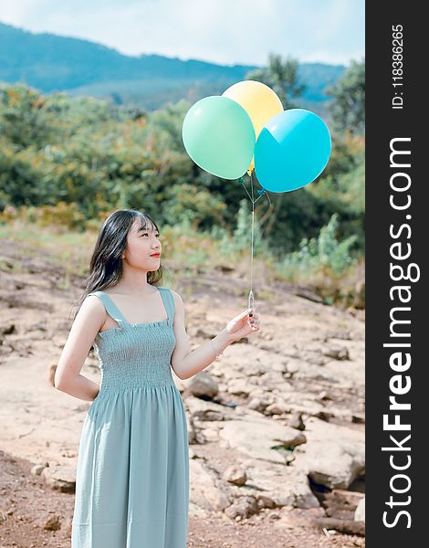 Woman In Dress Holding Balloons