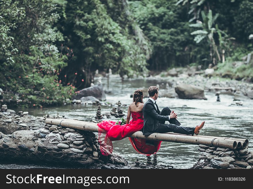 Man And Woman Sitting On Bamboos