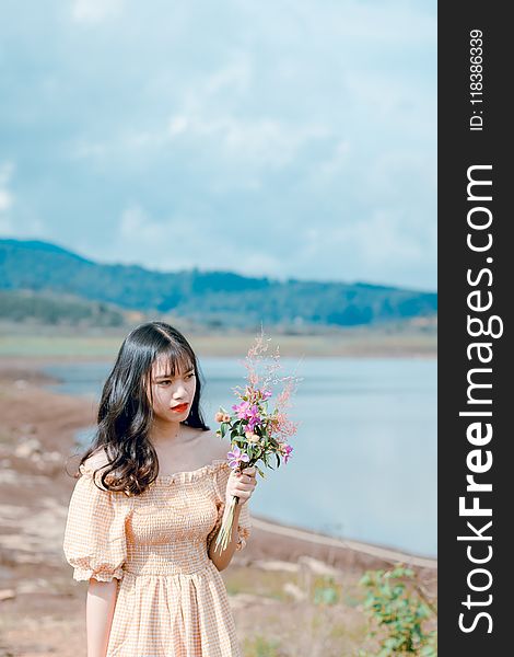 Photography Of A Woman Holding Flowers