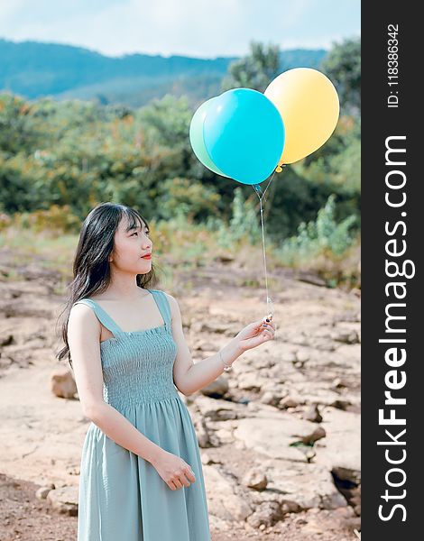 Woman Wearing Blue Dress Holding Balloons