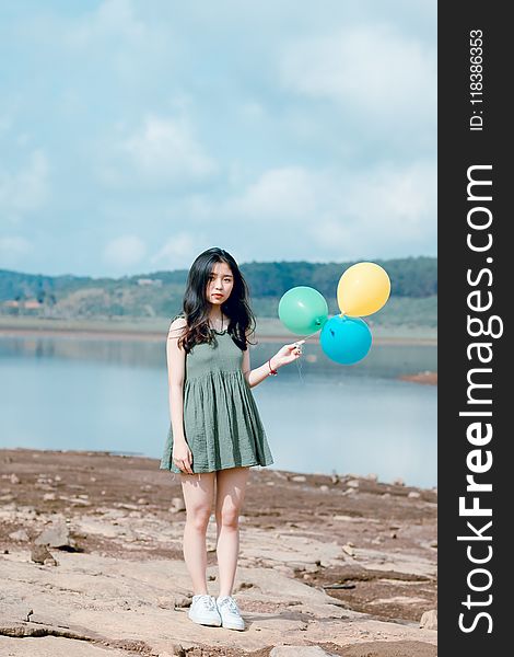 Photo of Girl Wearing Green Mini Dress Holding Balloons