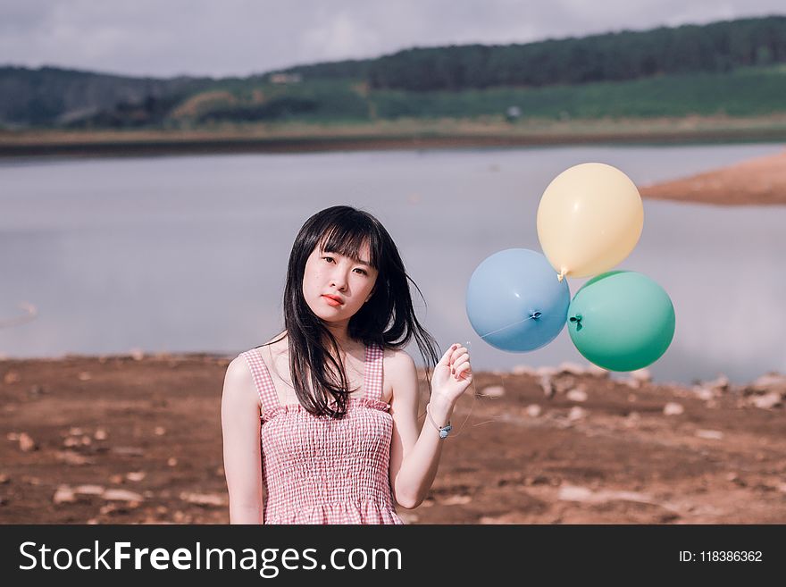 Girl in Pink Sleeveless Top Holds Three Party Balloons