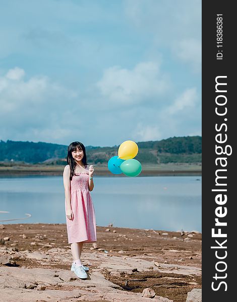 Woman in Pink Dress Holding Balloons
