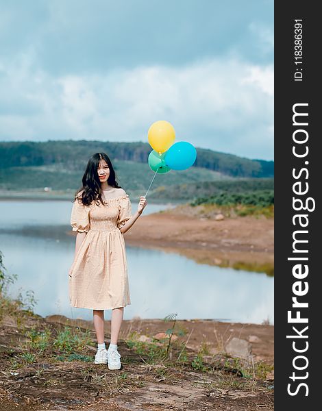 Shallow Focus Photography of Woman Holding Balloons