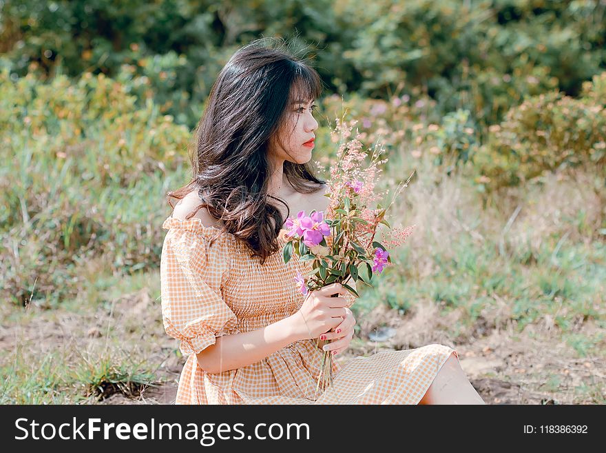Woman In Dress Holding Flowers