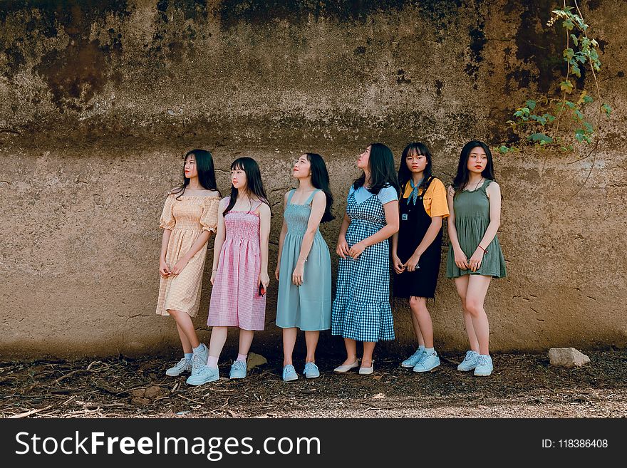 Photography Of Six Girl Standing Beside Wall