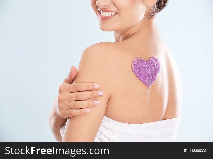 Woman With Heart Made Of Body Scrub On Her Back Against White Background