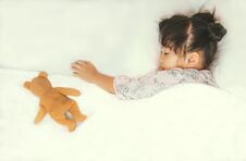 Cute Asian Child Sleepping With Her Teddy Bear,on White Bed Royalty Free Stock Photography