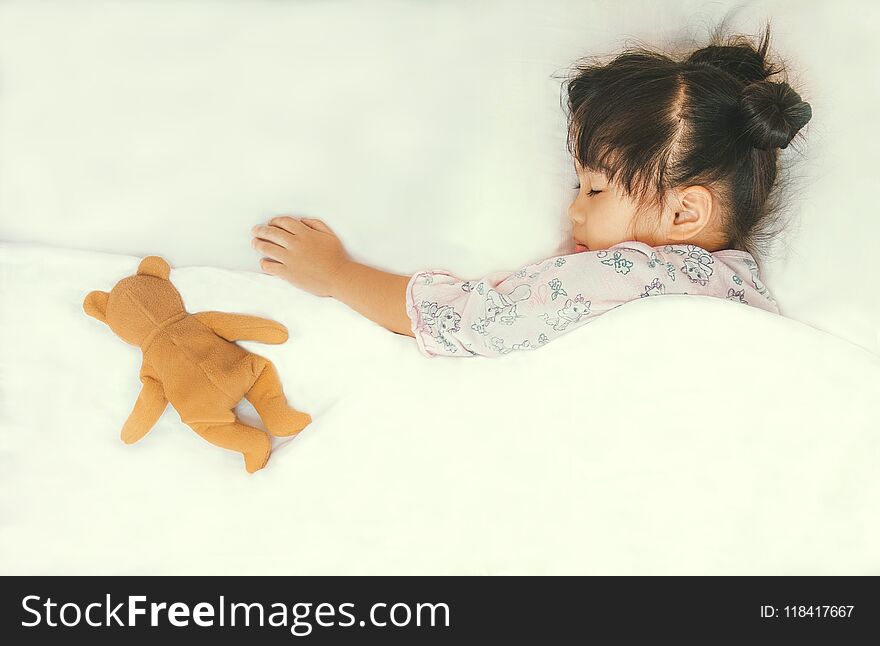 Cute Asian Child Sleepping With Her Teddy Bear,on White Bed