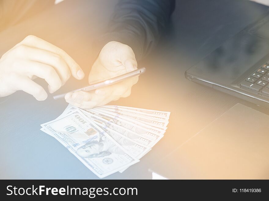 Technology, online banking, money transfer, e-commerce concept. Businessman using smartphone dollar bills flying on grey wall background. Internet earnings concept. Technology, online banking, money transfer, e-commerce concept. Businessman using smartphone dollar bills flying on grey wall background. Internet earnings concept