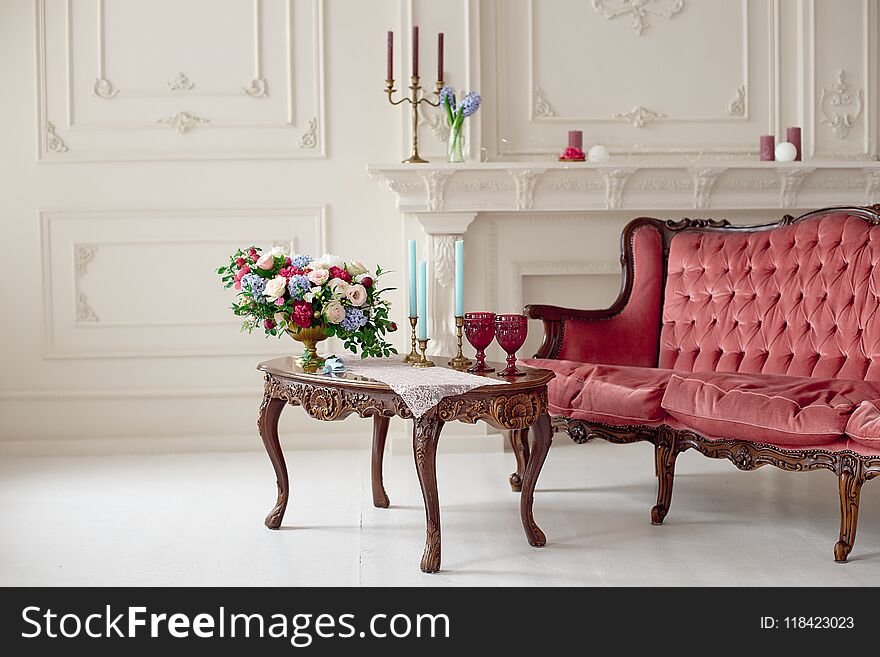 Baroque style interior with red luxury sofa and table in the middle