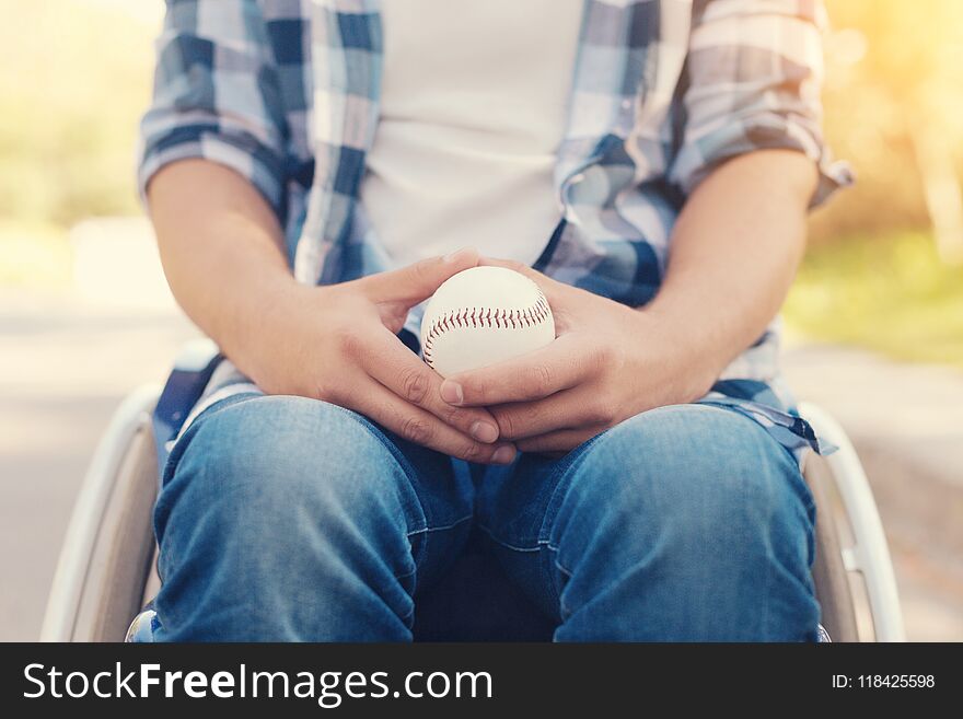 Sports games. Nice disabled person sitting in the armchair and holding a tennis ball while wanting to play. Sports games. Nice disabled person sitting in the armchair and holding a tennis ball while wanting to play