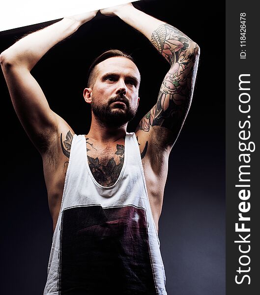 A man with tattooes on his arms. Silhouette of muscular body. ca