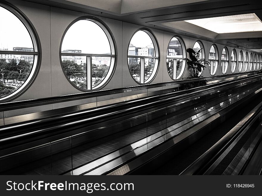 Black and white photo of airport walkway for faster and more efficient travel, composition with straight and cirular round lines. Black and white photo of airport walkway for faster and more efficient travel, composition with straight and cirular round lines