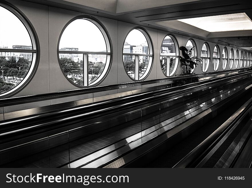 Airport Moving Walkway With Circular Windows In Black And White