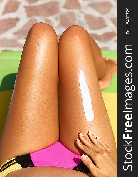 Woman applying sunscreen to her legs. sun cream