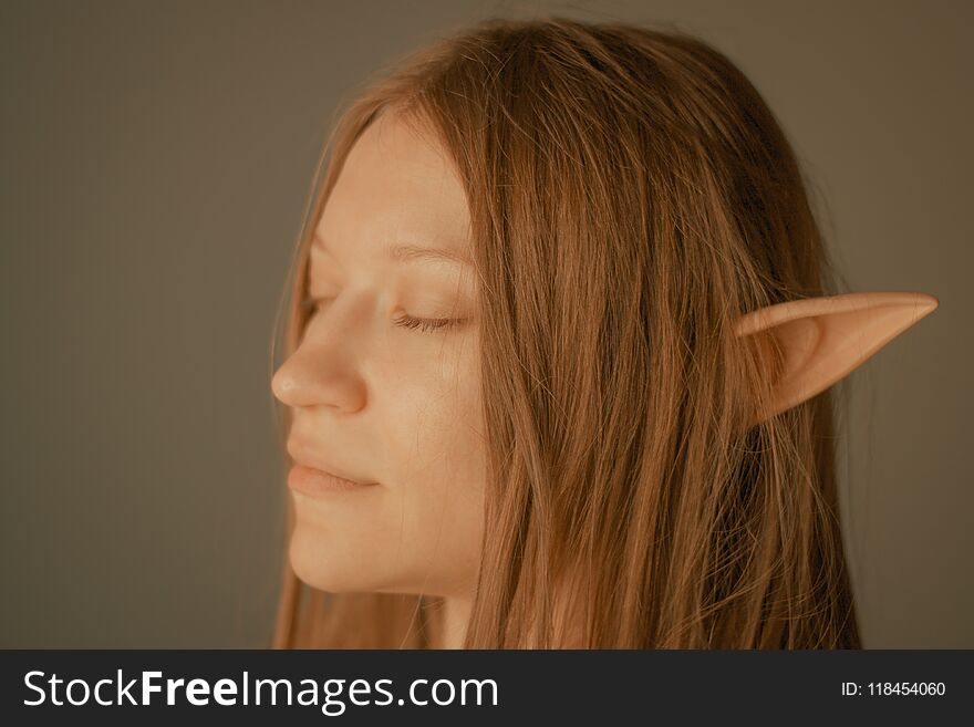 Beautiful girl with elf ears over grey background. Beautiful girl with elf ears over grey background