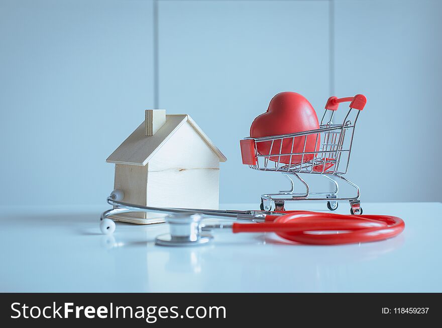 Mini shopping cart,Red heart with home model piggy bank on table,Health and money saving concept