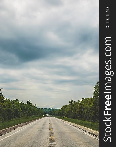 Empty Blacktop Road Under Cloudy Sky