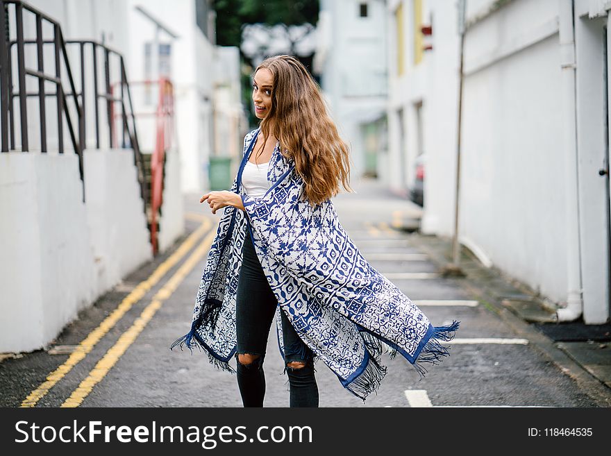 Woman Walking On Gray Pave Rod Near Building