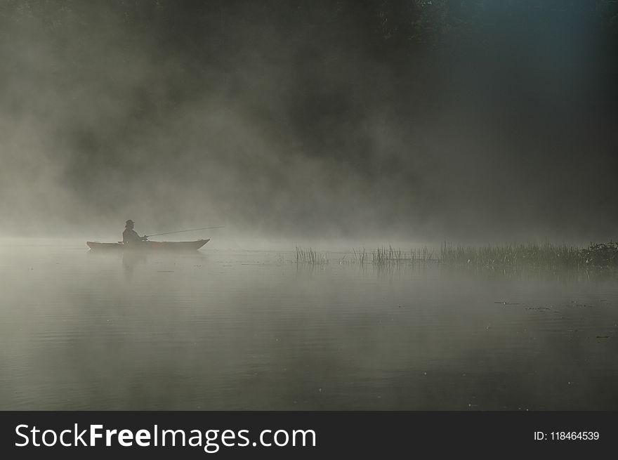 Person Riding Boat on Body of Water