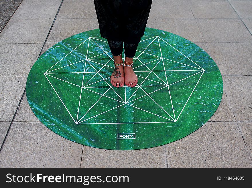 Person Standing on Green Round Mat