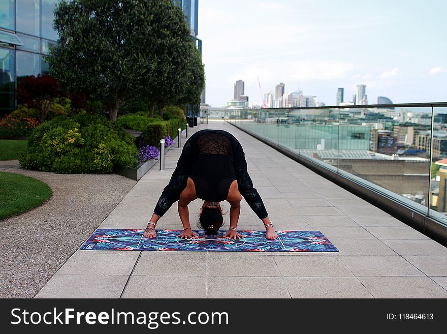Person Wearing Black Tank Top Doing Yoga Position
