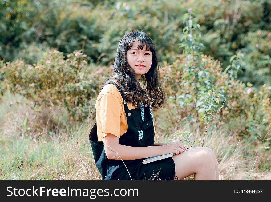 Shallow Focus Photography of Woman in Yellow Shirt and Black Dungaree