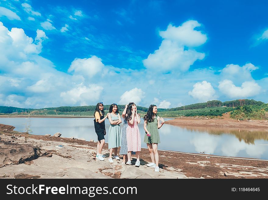 Four Women Standing Near Lake