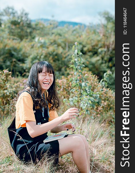 Woman Wearing Black Romper Sitting on Grass