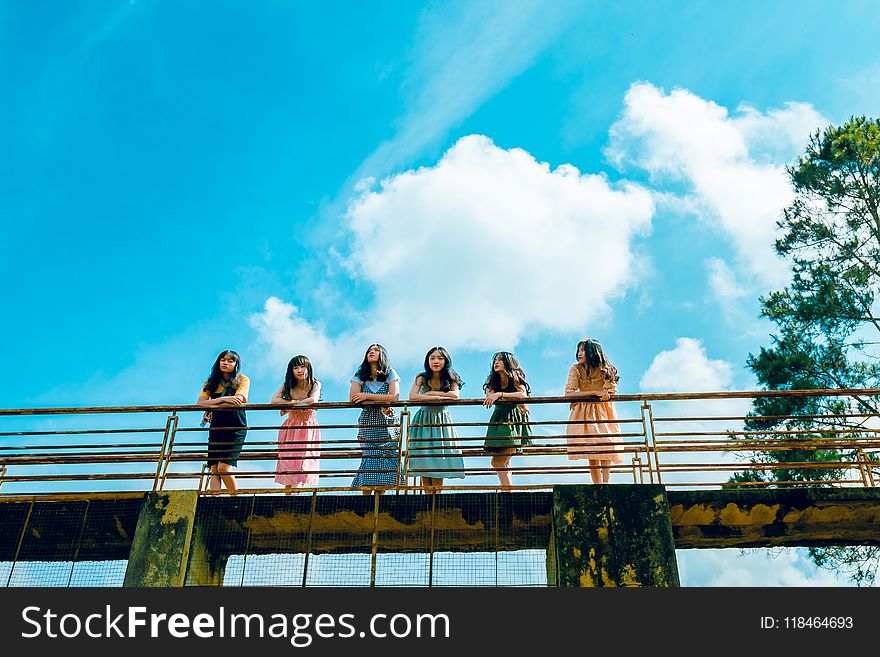 Six Women Wearing Dress Leaning on Bridge Rail