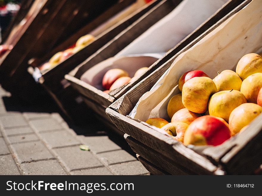 Yellow and Red Apples on Brown Crate