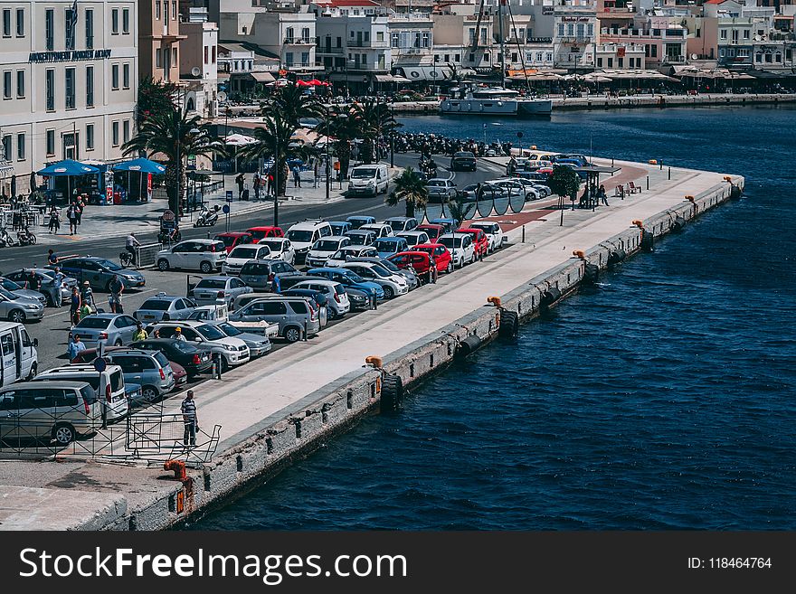 Cars Parked Near Buildings and Body of Water