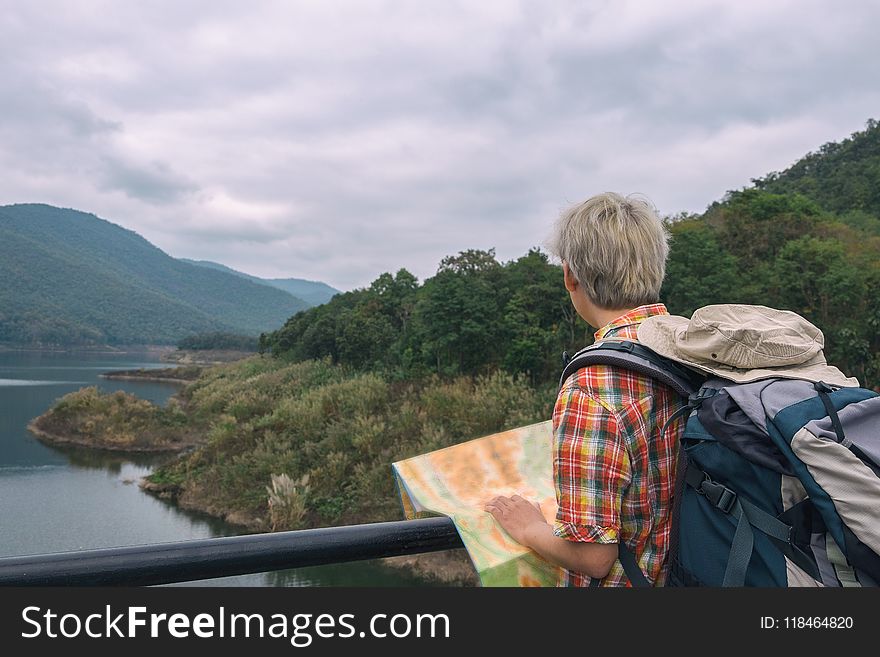 Man in Red, Yellow, Blue,and White Plaid Collared Top With Blue and Gray Backpack