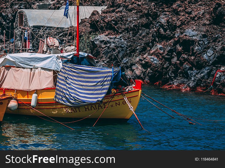 Yellow And Red Boat On Body Of Water