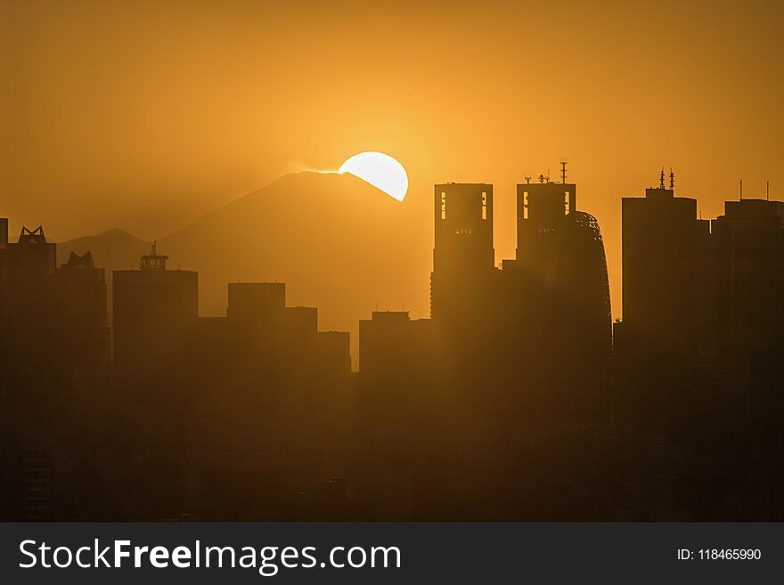 Tokyo Shinjuku building with Top of mountain fuji at sunset in winter season. Mount Fuji lies about 100 kilometres south-west of Tokyo, and can be seen from there on a clear day.