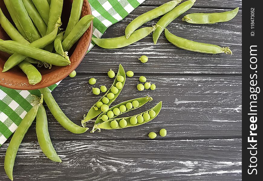 Fresh green peas vitamin on a black wooden background