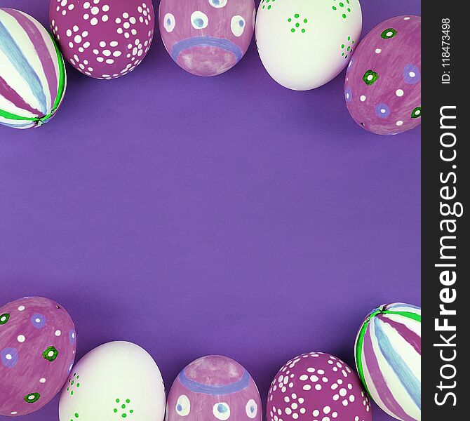 Painted Easter eggs on purple background with empty space for text