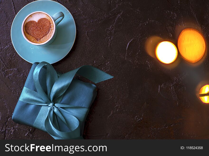 Coffee in a mint cup with a heart pattern and a gift wrapped