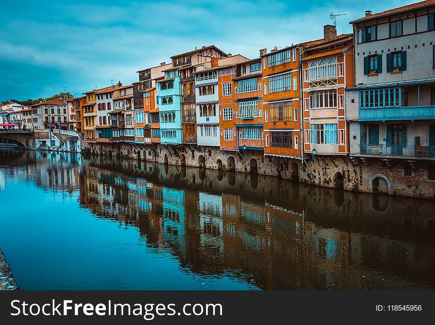 Assorted-color Concrete Buildings Beside River At Daytime