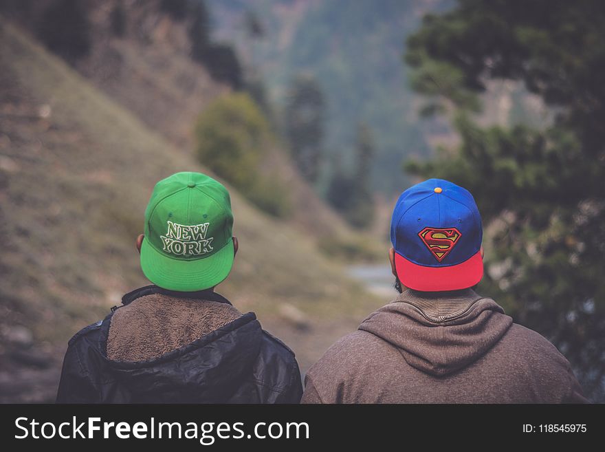 Shallow Focus Photography of Two Men Wearing Caps